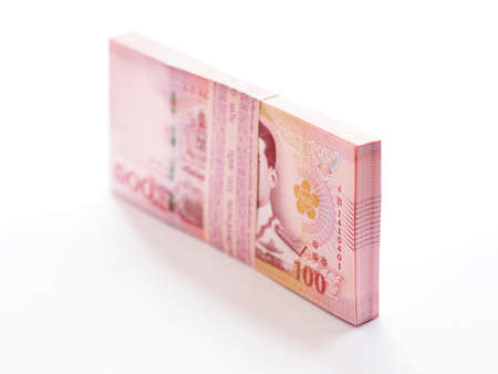 Close up pile of Thai 100 baht banknotes on white background, perspective view.