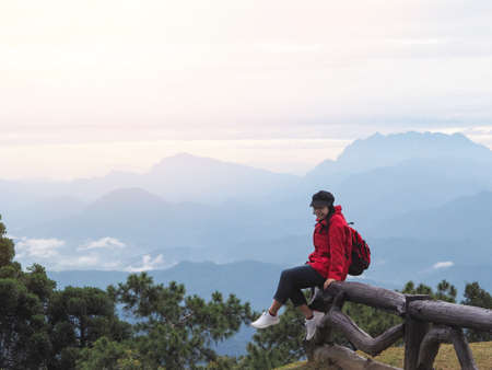 Happy Asian woman tourist enjoying over mountain view with fog background at Huai Nam Dang National...