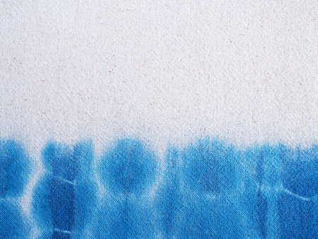 Close up indigo tie-dye on beige cotton fabric texture. Natural vintage textile background.