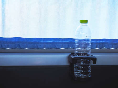 Close up water bottle on cup holder in van nearby glass window. Faciclity equipment in car.の写真素材
