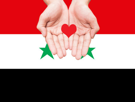 Two hands holding small heart shape over flag of Syria background. Save and help concept.の写真素材