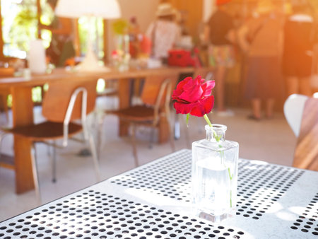 Close up transparent glass of red rose on table at coffee shop. 
Flower bouquet arrangement decoration.の写真素材