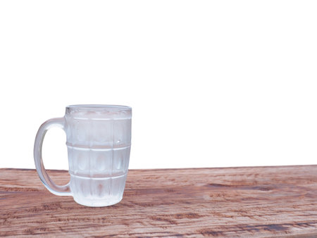 Close up glass of cold water on wooden table top isolated on white backgroundの写真素材