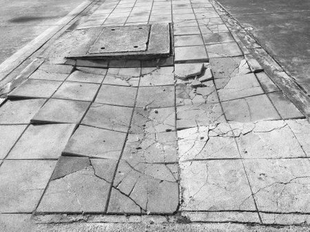 Old cracked footpath. Broken slabs walkway in the city.の写真素材
