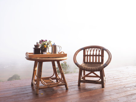 Rattan chair and table with coffee set at vintage terrace in the misty morningの写真素材