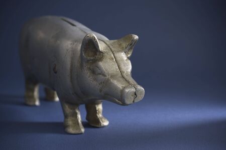 Cast iron antique piggy bank on a dark blue background.の写真素材
