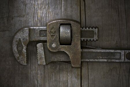 Trusty, old wrench on an old wooden workshop bench.の写真素材