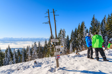 GORCE MOUNTAINS, POLAND - FEB 14, 2015: tourists standing near mountain trail sign near Turbacz shelter. Winter camp takes placeのeditorial素材