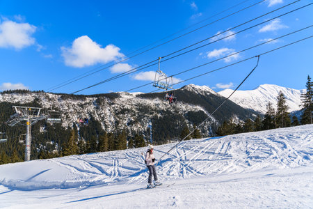ROHACE SKI RESORT, SLOVAKIA - MAR 7, 2015: skier on lift in beautiful winter scenery of Tatra Mountains. The upper station of chのeditorial素材