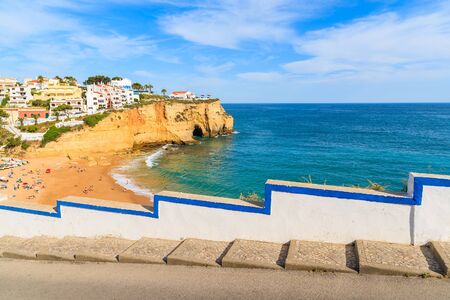 Street in Carvoeiro fishing village with view of beautiful beach, Algarve, Portugalの写真素材