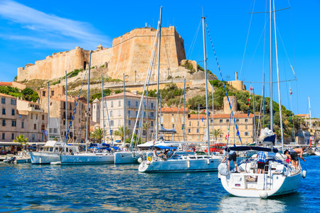 BONIFACIO PORT, CORSICA ISLAND - JUN 25, 2015: sailing yacht boats anchoring in Bonifacio port with citadel building in backgrouのeditorial素材