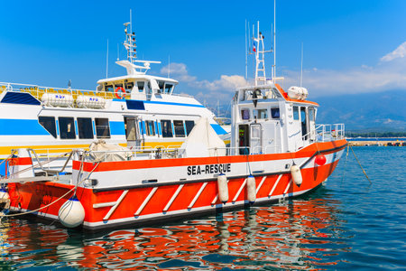 CALVI, CORSICA ISLAND - JUN 28, 2015: rescue ship and tourist boat mooring in Calvi port. This town...