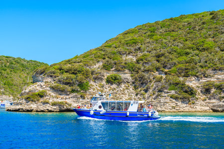 CORSICA ISLAND, FRANCE - JUN 25, 2015: tourist boat on cruising on sea near Bonifacio limestone cliff rocks. Bonifacio is most vのeditorial素材