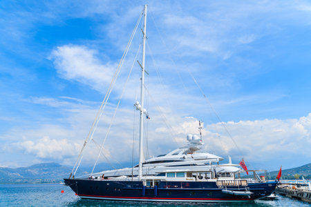CALVI PORT, CORSICA ISLAND - JUN 29, 2015: luxury sail boat on sea against beautiful sky with white...