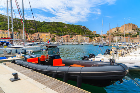 BONIFACIO PORT, CORSICA ISLAND - JUN 25, 2015: boats anchoring in Bonifacio port with citadel building in background.のeditorial素材