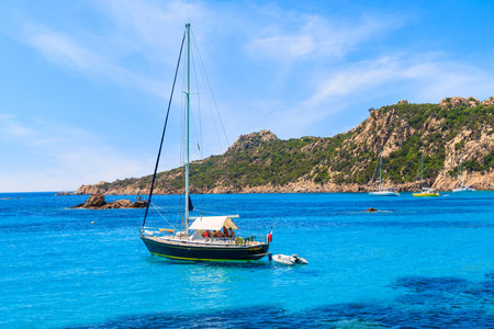 CORSICA ISLAND, FRANCE - JUN 24, 2015: A sailing boat on blue sea mooring in a bay on coast of Corsica island, France.のeditorial素材