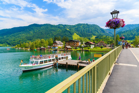 WEISSENSEE LAKE, AUSTRIA: tourist boat "Weissensee" mooring to pier on shore of Weissensee lake in summer landscape of Alps Mountainのeditorial素材