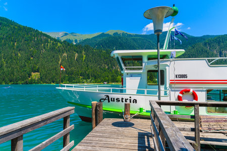 WEISSENSEE LAKE, AUSTRIA - JUL 7, 2015: "Austria" tourist boat mooring on shore of Weissensee lakeのeditorial素材