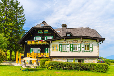 WEISSENSEE LAKE, AUSTRIA - JUL 6, 2015: Typical alpine guest house on green meadow in summer landscape of Weissensee lake, Austriaのeditorial素材