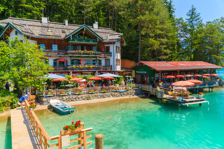WEISSENSEE LAKE, AUSTRIA - JUL 7, 2015: restaurant and guest house on shore of Weissensee lake in summer time.のeditorial素材