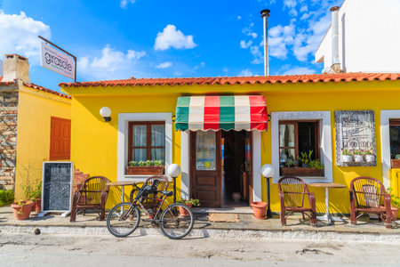 SAMOS ISLAND, GREECE - SEP 24, 2015: bicycle parked in front of Italian restaurant on street of Kokkari town, Samos island, Greeceのeditorial素材