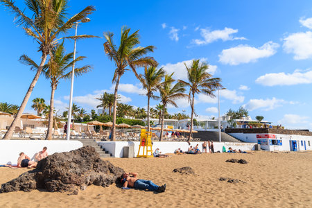 PUERTO DEL CARMEN BEACH, LANZAROTE ISLAND - JAN 17, 2015: tropical beach with palm trees in Puerto del Carmen town.のeditorial素材