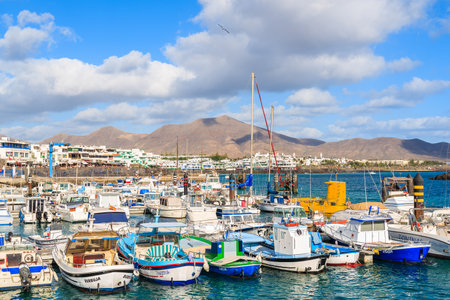 PLAYA BLANCA PORT, LANZAROTE ISLAND - JAN 17, 2015: colourful fishing boats in Playa Blanca harbour on sunny day. Lanzarote is very popular tourist destination among Canary Islands archipelago.のeditorial素材