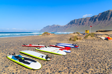 FAMARA BEACH, LANZAROTE - JAN 15, 2015: surfing boards on Famara beach which is famous for best ocean waves on Lanzarote island. Canary Islands are popular destination for water sport lovers.のeditorial素材