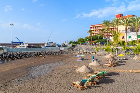 SAN JUAN BEACH, TENERIFE ISLAND - NOV 15, 2015: sunbeds wuth umbrellas on a beach in San Juan town on Tenerife island, Spain.のeditorial素材