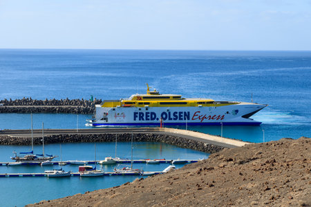 MORRO JABLE, FUERTEVENTURA - FEB 8, 2014: Fred Olsen fast ferry ship enters harbour in Morro Jable. This port town is popular seaside destination for tourists.のeditorial素材