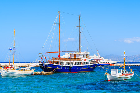 MYKONOS PORT, GREECE - MAY 17, 2016:Sailing and fishing boats on blue sea in Mykonos port, Mykonos...