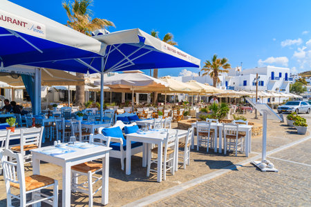 PAROS ISLAND, GREECE - MAY 20, 2016: restaurant tables waiting for tourists in Naoussa port, Paros island, Greece.のeditorial素材