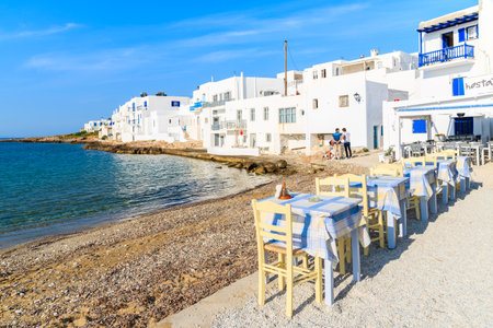 PAROS ISLAND, GREECE - MAY 19, 2016: tavern tables on beach in Naoussa village on Paros island, Greece.のeditorial素材