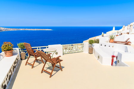 Two chairs on a terrace in Oia village with beautiful sea view, Santorini island, Greeceのeditorial素材