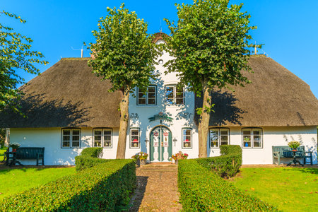 SYLT ISLAND, GERMANY - SEP 8, 2016: typical white house with thatched roof in Wenningstedt village on Sylt island, Germany.のeditorial素材
