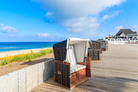 SYLT ISLAND, GERMANY - SEP 6, 2016: wicker chair and restaurant on coastal promenade in Wenningstedt village on Sylt island, Germany.のeditorial素材