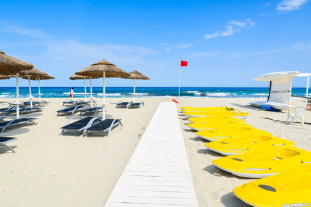 PORTO GIUNCO BEACH, SARDINIA - MAY 25, 2014: yellow kayaks and umbrellas with sun chairs on Porto Giunco beach, Sardinia island, Italy. South of the island has most beautiful beaches in Europe.のeditorial素材