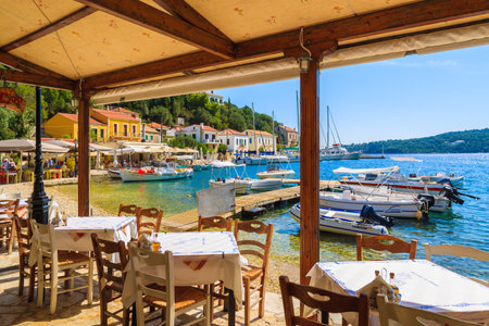 KIONI PORT, ITHACA ISLAND - SEP 19, 2014: tables in Greek restaurant in Kioni port. Greece is very popular holiday destination in Europe.のeditorial素材