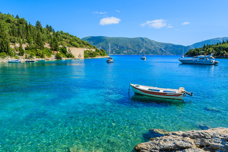 Fishing boat and yacht on turquoise sea in bay near Fiskardo village, Kefalonia island, Greeceの写真素材