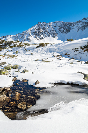 Frozen lake covered with snow in 5 lakes valley, High Tatra Mountains, Polandの写真素材