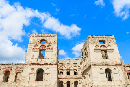 Stone towers of medieval castle Krzyztopor against blue sky with white clouds, Ujazd, Polandのeditorial素材