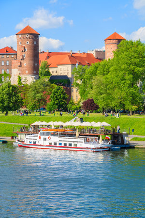 Tourist boat on Vistula river with Wawel Royal Castle in the background on sunny beautiful day, Polandのeditorial素材
