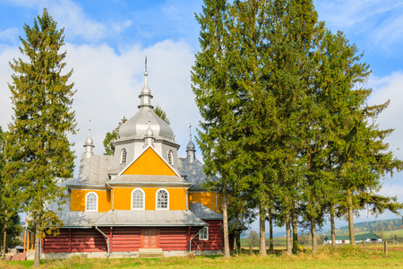Beautiful yellow old wooden orthodox catholic church in Gladyszow village, Beskid Niski Mountains, Polandの写真素材