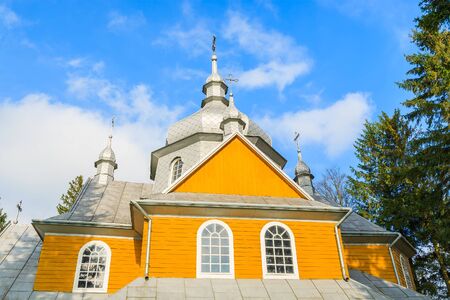 Beautiful yellow facade of old wooden orthodox catholic church in Gladyszow village, Beskid Niski Mountains, Polandの写真素材