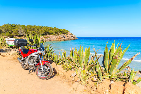 IBIZA ISLAND, SPAIN - MAY 20, 2017: motorcycle parking on shore of Cala Nova bay on sunny summer day, Ibiza island, Spain.のeditorial素材