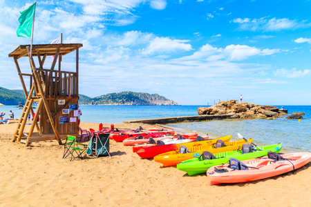 IBIZA ISLAND, SPAIN - MAY 18, 2017: Lifeguard tower and colourful kayaks on sandy Es Figueral beach, Ibiza island, Spain.のeditorial素材