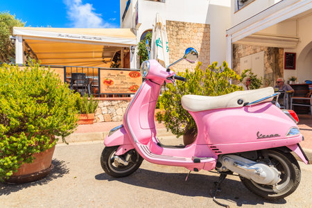 IBIZA ISLAND, SPAIN - MAY 18, 2017: classic pink Vespa scooter parking in garden of traditional restaurant in Sant Carles de Peralta village, Ibiza island, Spain.のeditorial素材