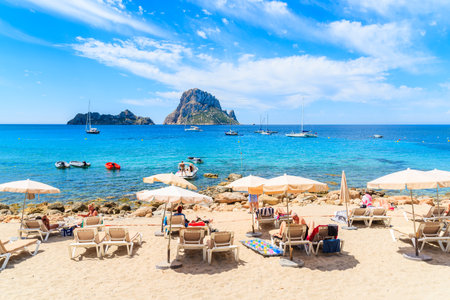 IBIZA ISLAND, SPAIN - MAY 18, 2017: Tourists sunbathing on idyllic beach of Cala d'Hort, Ibiza island, Spain.のeditorial素材
