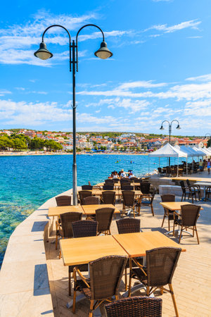 PRIMOSTEN PORT, CROATIA - SEP 5, 2017: Restaurant tables in Primosten old town port, Dalmatia, Croatia.のeditorial素材