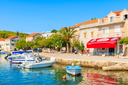 SUMARTIN PORT, BRAC ISLAND - SEP 13, 2017: fishing boats and restaurant in Sumartin port on sunny summer day, Brac island, Croatia.のeditorial素材